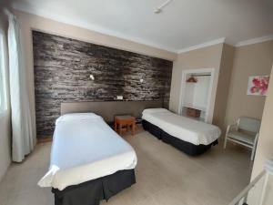 埃尔阿雷纳尔银海旅馆的砖墙客房的两张床