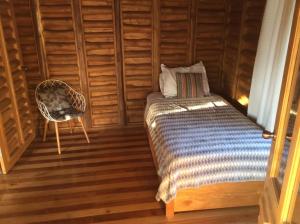 巴希利托Maison autonome en bois, à Brasilito的一间卧室,卧室内配有一张床和一把椅子