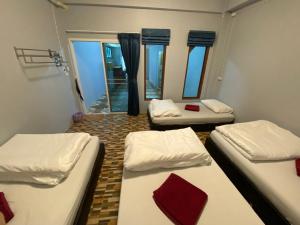 考索Boom Hostel Khao Sok的带窗户的客房内的三张床