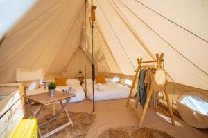 塞洛里奥Kampaoh Playa Troenzo的带帐篷、床和桌子的客房