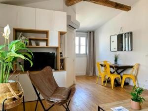 蒙彼利埃Home Chic Home - Les Toits de Sainte-Ursule的客厅设有餐桌和黄色椅子