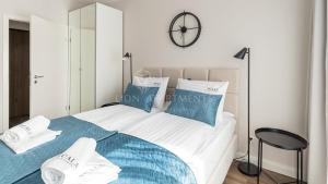 格但斯克Lion Apartments - SCALA City Center Apartments&Studio IIA的一间卧室配有一张带蓝色和白色枕头的床
