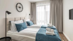 格但斯克Lion Apartments - SCALA City Center Apartments&Studio IIA的一间卧室配有一张带蓝色枕头的大床