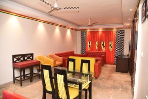 浦那BelAir Suites Pune的一间设有红色和黄色椅子和桌子的等候室