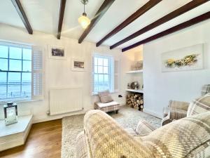 斯泰兹Harbourside的客厅拥有白色的墙壁和木制天花板。