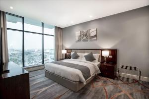 多哈فندق شراعوه الملكي - Luxury的一间卧室设有一张大床和大窗户
