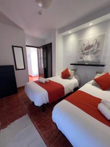 洛斯克里斯蒂亚诺斯Apartamentos Funchal的酒店客房带两张红色和白色的床单
