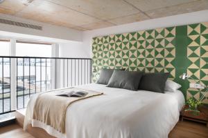 阿姆斯特丹Eric Vökel Boutique Apartments - Riverfront Suites的一间卧室配有一张白色的床和绿色的墙壁
