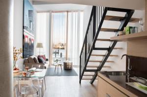 阿姆斯特丹Eric Vökel Boutique Apartments - Riverfront Suites的厨房和带螺旋楼梯的客厅