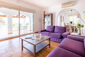 苏昂博Villa Dreams的客厅配有紫色沙发和桌子