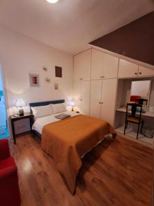 圣朱利安斯Rotas B&B的一间卧室配有一张大床和一张红色的沙发