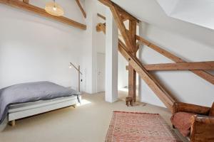 VuissensCompletely refurbished typical Swiss farmhouse的一间白色的卧室,配有床和楼梯