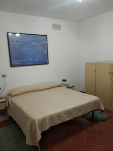 奇尼斯B&B vacanze Mille Colori的卧室配有一张床,墙上挂有绘画作品