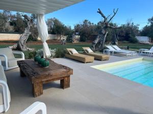莱乌卡Villa Gabriella的一个带桌椅的庭院和一个游泳池