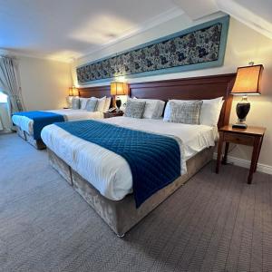 凯尔斯黑德福特阿姆斯酒店的酒店客房,配有两张带蓝色床单的床