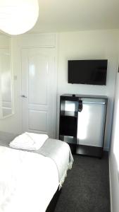 格拉斯哥New & delightful 3 bed house in East Kilbride的一间卧室配有一张床和一台平面电视
