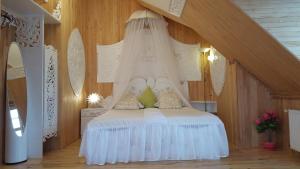 尤尔马拉奈瑟旅馆的一间卧室配有一张带天蓬的白色床