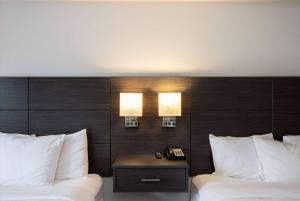贝灵厄姆Baymont INN & Suites by Wyndham的酒店客房设有两张床和一张桌子及电话