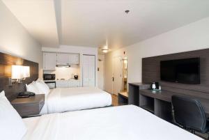 贝灵厄姆Baymont INN & Suites by Wyndham的酒店客房设有两张床和一台平面电视。