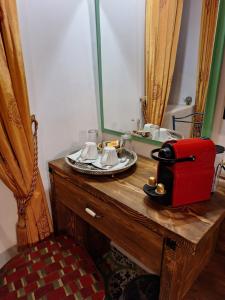 罗德镇Nikos Takis Fashion Boutique Hotel的浴室设有梳妆台、镜子和红色的行李箱