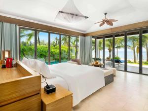 富国富国岛诺富特度假酒店的卧室设有一张大白色床,享有海景