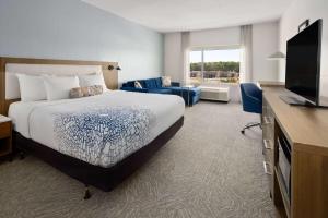 洛克斯特格罗夫La Quinta Inn & Suites by Wyndham Locust Grove的配有一张床和一台平面电视的酒店客房