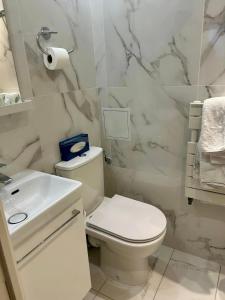 巴黎德尔比埃菲尔酒店的白色的浴室设有卫生间和水槽。