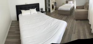 MontagnieuHotel Restaurant Rolland的卧室配有一张白色大床和一把椅子