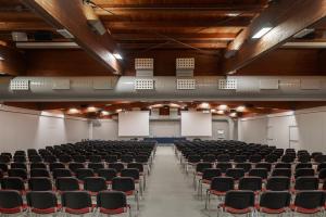 萨韦纳河畔圣拉扎罗UNAHOTELS Bologna San Lazzaro的一个空的讲堂,有黑椅子和白板