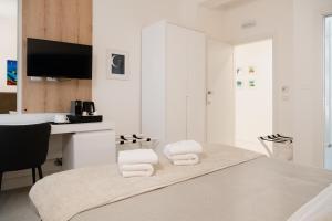 莱切Lo Studio di viale Lo Re camere & caffe’的白色的客房设有一张桌子和毛巾