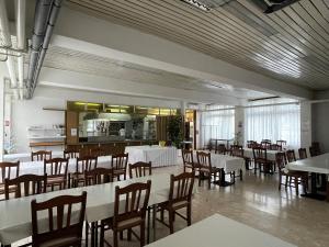 萨格勒布Hostel Arena的用餐室配有白色的桌子和木椅