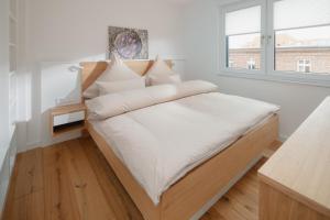 诺德奈die ELF的一间卧室配有一张带白色床单的床和一扇窗户。