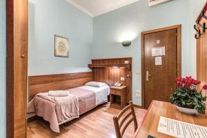 罗马阿尔塔维拉酒店的一间卧室配有一张床、一张桌子和一张桌子。