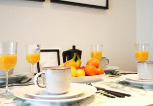 马德里Apartamento Marques de Zafra - Ventas的桌子,上面放着橙汁和一碗橘子