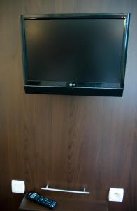 梅朗乐莫卡酒店的木墙上的平面电视,配有两个遥控器