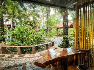 董里Pang Long Chao resort的庭院设有长椅、桌子和树木