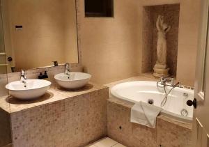 凯尔斯黑德福特阿姆斯酒店的浴室配有两个盥洗盆和浴缸。