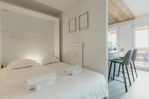 克莱恩 蒙塔纳Magnifique appartement proche du centre的白色卧室配有白色的床和书桌