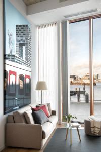 阿姆斯特丹Eric Vökel Boutique Apartments - Riverfront Suites的带沙发和大窗户的客厅