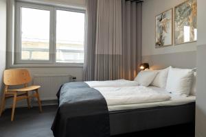哥本哈根CPH Hotel的卧室配有床、椅子和窗户。