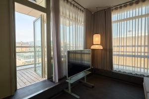 哥本哈根CPH Hotel的客房设有带书桌和台灯的大窗户。