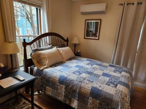 萨默维尔Davis Square Inn的一间卧室配有一张床、一张桌子和一个窗户。