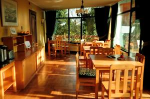 蒙特港塞米纳里奥酒店的餐厅设有木桌、椅子和窗户。