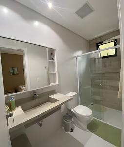 约恩维利Aconchegante Casa 3 suites no Atiradores的浴室配有卫生间、盥洗盆和淋浴。
