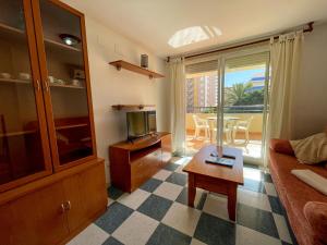 奥罗佩萨德尔马Apartamentos Bonaire 3000的带沙发、电视和桌子的客厅