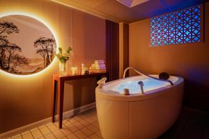 杜瓦讷内Hôtel Valdys Thalasso & Spa - la Baie的带浴缸的浴室和大窗户