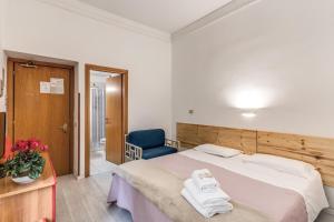 罗马阿尔塔维拉9号酒店的一间卧室配有一张大床和一张蓝色椅子