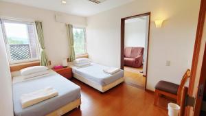 中富良野町拉库琳娜膳食公寓&餐厅的一间卧室配有两张床、镜子和椅子