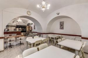 罗马阿尔塔维拉9号酒店的一间设有白色桌子和白色椅子的餐厅