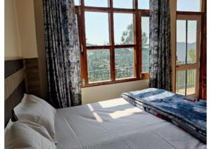 西姆拉Goroomgo Homestay Sukh Dham Shimla - Homestay Like Home Feeling Mountain View的一间卧室设有一张床和一个开放式窗户。